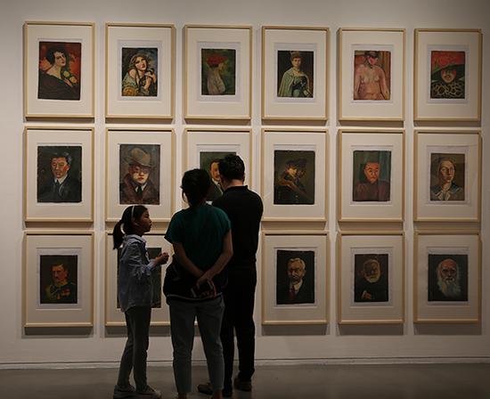 展览现场，背景为郑慕康作品《18件上海美专函授作业·人物习作》